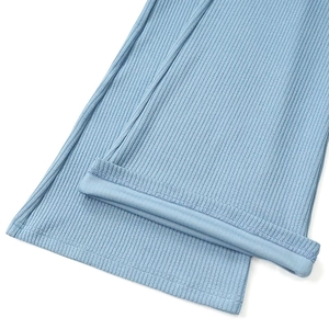 Détail du pantalon en maille côtelée bleu clair montrant les coutures de l'ourlet fini