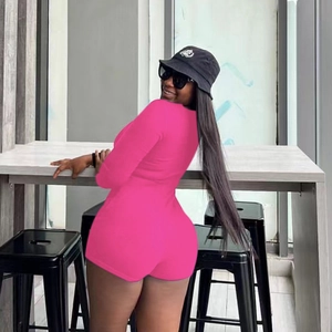 Slim fit rose pink long sleeve hollow-out romper modeled in a modern interior setting