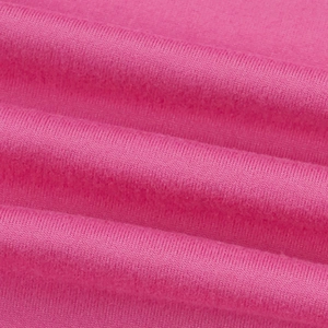 Détail macro du tissu en maille côtelée rose montrant la texture douce et les plissés