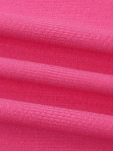 Gros plan sur le tissu jersey rose vif en mélange de coton montrant la maille et les plis