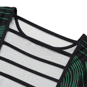 Detail eines schwarzen Kleides mit grünen Streifen und geometrischem Cut-Out-Ausschnitt