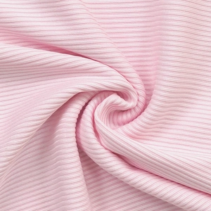 Gros plan sur un tissu en maille côtelée rose clair montrant texture et élasticité