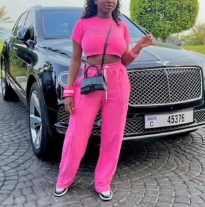 Détail d'un ensemble de sport rose vif avec broderie Starry sur le haut court et le pantalon