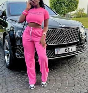 Détail d'un ensemble sport rose deux pièces avec imprimé STARK et pantalon à cordon