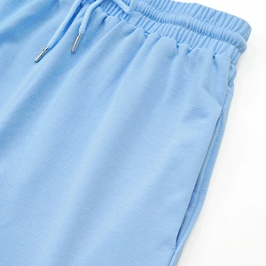 Detail of light blue tracksuit showing elastic waist with metallic tipped drawstrings