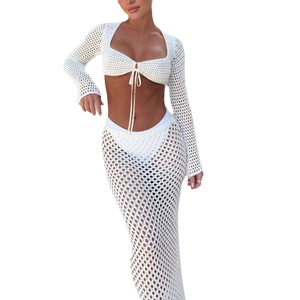 White crochet two-piece set featuring long sleeve tie-up top and matching knit maxi skirt