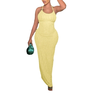 Eng anliegendes hellgelbes Popcorn-Strickkleid mit Neckholder und grüner Satintasche
