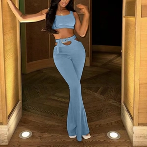 Détail d'un crop top bleu sans manches et d'un pantalon évasé à taille haute avec boucle