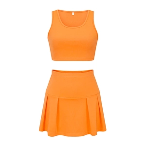 Detail of orange athletic set showing sleeveless tank top and pleated skirt fabric quality