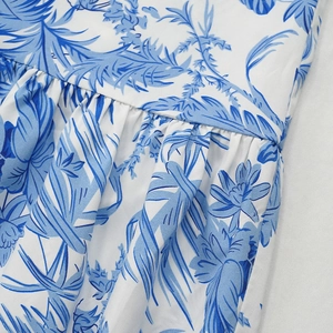 Vue détaillée de la robe blanche avec imprimés de palmiers bleus et taille plissée