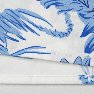 Détail de l'imprimé palmier bleu sur tissu blanc avec des coutures et textures de qualité