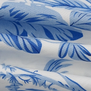 Détail macro du textile tissé avec des motifs de feuilles bleues sur un tissu blanc