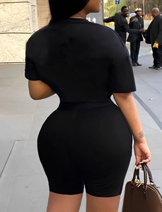 Rear view of women's casual two-piece set featuring black t-shirt and slim cycling shorts