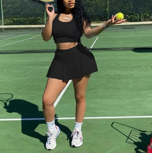 Detail of black sports set with halter top and pleated skirt on a tennis court