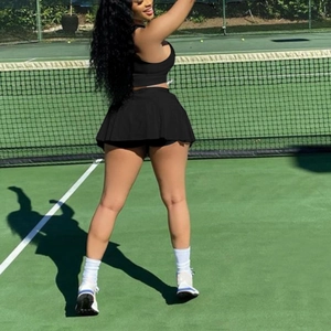 Women's black two-piece tennis set with slim fit sports tank top and pleated skirt