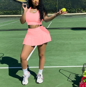 Outdoor shot of a pink two-piece tennis set with halter top and pleated skirt