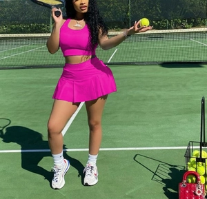 Detail of rose pink athletic two-piece set featuring slim fit tank top and pleated skirt