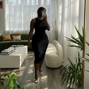 Detail of the vertical ribbed texture and slim fit design on this black sleeveless dress