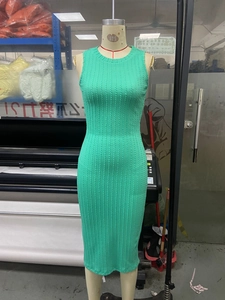 Detail of green sleeveless knit dress showing textured vertical ribbed fabric and round neck