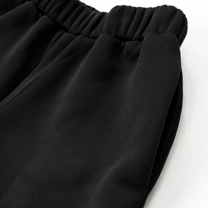Detail of elastic waistband and side pockets on thick black knitted sweatpants