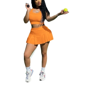 Slim fit two-piece orange sports tennis set with halter neck top and pleated mini skirt