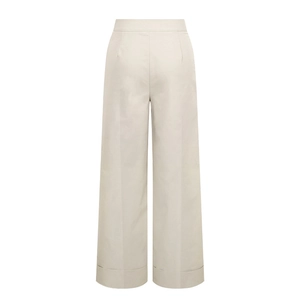 Detail of high-waist wide-leg pants in beige with cuffed hems and sharp center creases