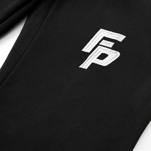 Close-up of white logo embroidery on high-quality black knit fabric for tracksuit