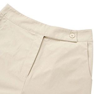Detail of waist design with offset button closure and pockets on beige casual trousers