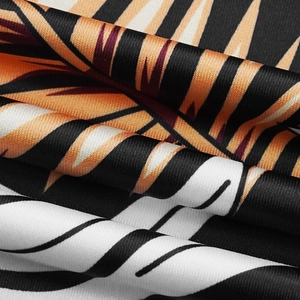 Ensemble deux pièces avec imprimé feuilles tropicales orange et noir, tissu lisse