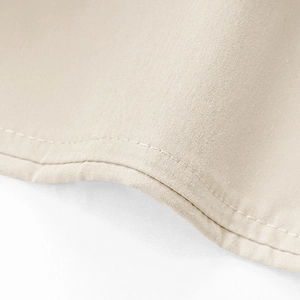 Detailed macro view of beige linen fabric texture and premium stitching on trousers