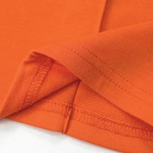 Detail of orange trousers showing high-quality double-needle stitching and french terry fabric