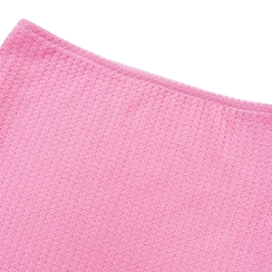 Nahaufnahme von rosa Waffelstrickstoff mit detaillierten Nähten und Texturmustern