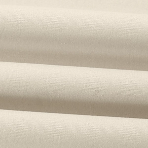 Macro texture of cream canvas fabric showing weave patterns and soft material folds