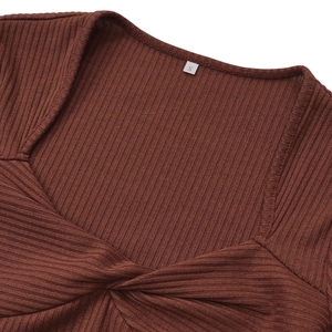 Detail view of coffee brown knit top featuring twist-front neckline and ribbed texture