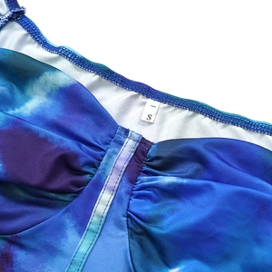 Detail of crop top with tie-dye blue and purple print, ruched neckline and size S label