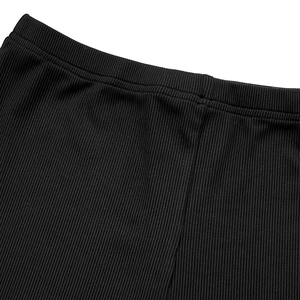 Detailed macro view of the thick black ribbed knit fabric and seamless elastic waistband