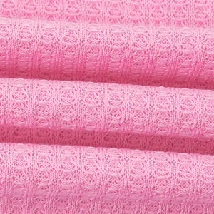 Makroaufnahme von rosa Waffelstrick-Stoffstruktur und hochwertigem Baumwollmischgewebe