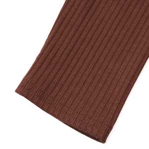 Detailed macro view of the brown ribbed knit fabric texture on the sleeve cuff