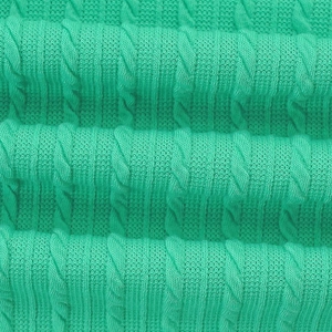 Detailed close-up showing the green cable-knit texture and soft fabric of the dress