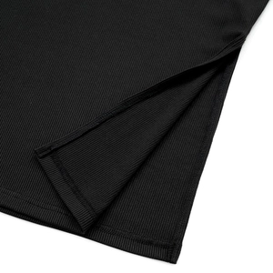 Detail shot of the split hem on black ribbed knit crop top and pants set fabric