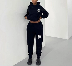 Detail of black cotton fleece tracksuit featuring white printed logo on hoodie and joggers