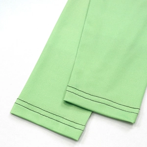 Detailed close-up of light green knit fabric with precise black double-needle stitching