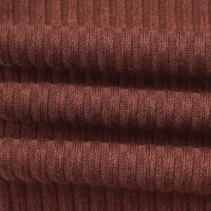 Detailed macro view of the ribbed texture on a tan-colored knit long-sleeve crop top