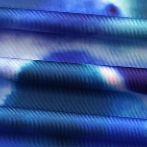 Macro view of blue tie-dye ribbed knit fabric with vertical stripes and soft texture
