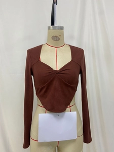 Detail of dark brown ribbed knit top featuring a unique twisted square neck and pointed hem
