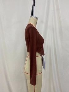 Detailed side view of brown ribbed knit crop top with slim fit and curved hem design