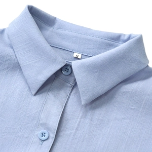 Detail shot of the light blue shirt collar and buttons with textured linen fabric