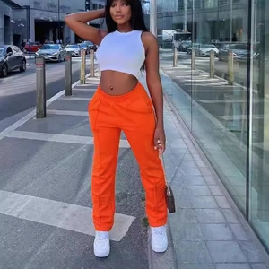 Women's chic white sleeveless crop top paired with bright orange straight leg casual pants