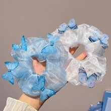 Detailed view of sky blue and white organza scrunchies with mesh butterfly and pearl accents