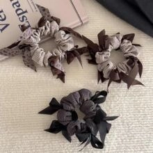 Detailed close-up of three elegant bow hair scrunchies in coffee, plaid, and black colors
